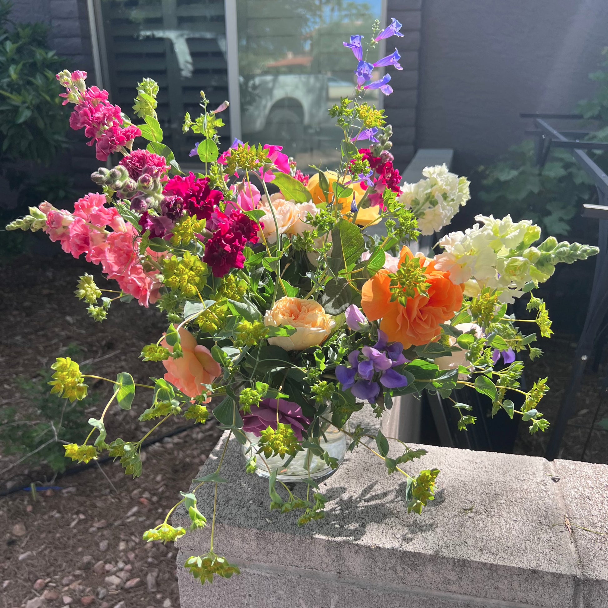 an example of an "Extra" sized bouquet with roses, larkspir, snapdragons, sweet peas, bupleurum, and bay leaf