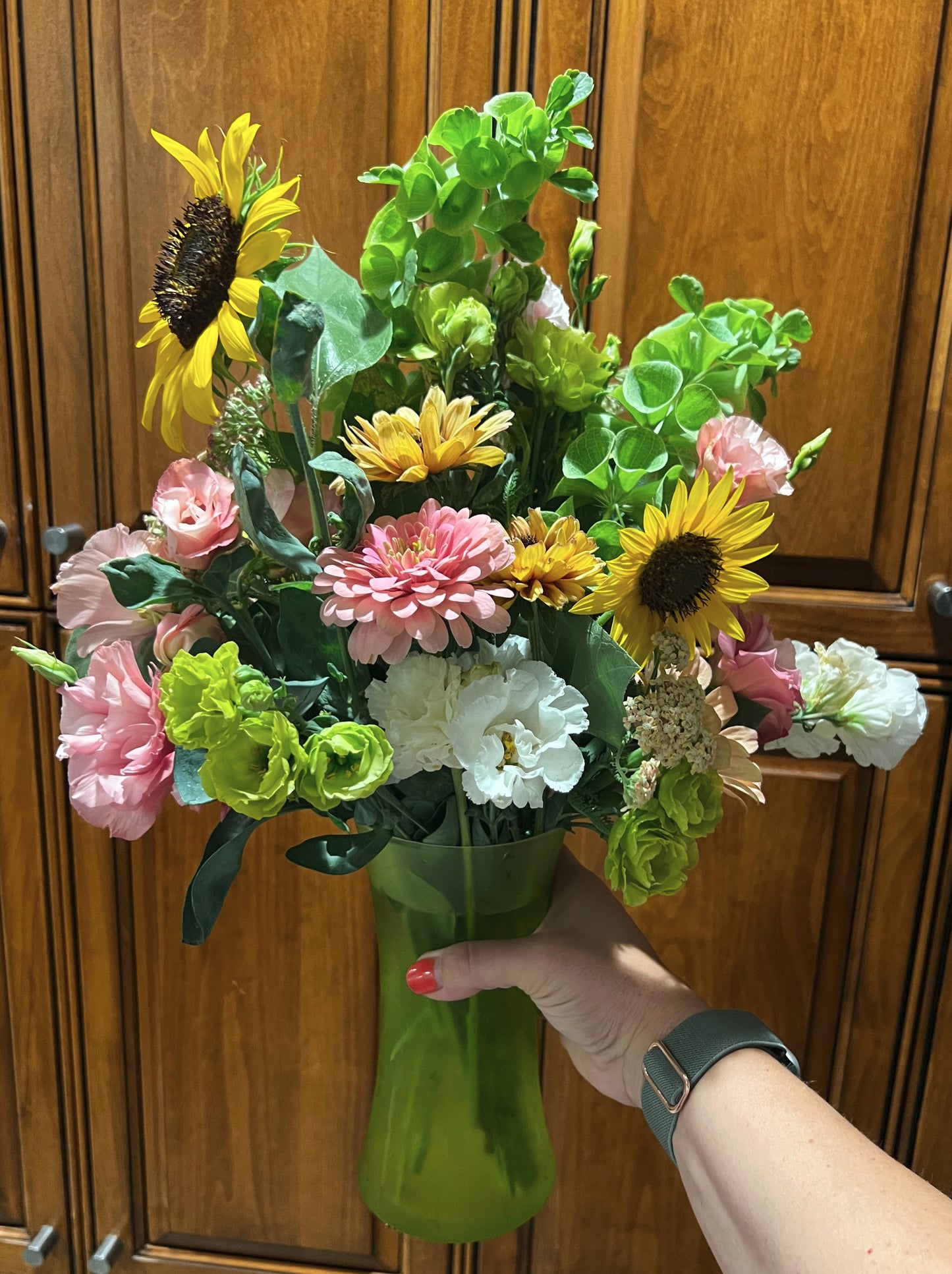 An example of a large early summer bouquet with sunflowers, lisianthus, rudbeckis, zinnias and bells of ireland