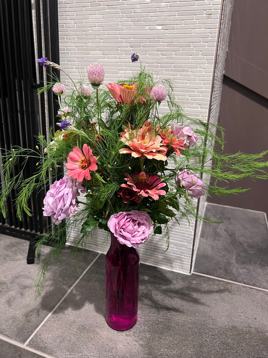 an example of a mid summer medium bouquet with roses, gomphrena, zinnias, lavender and asparagus fern